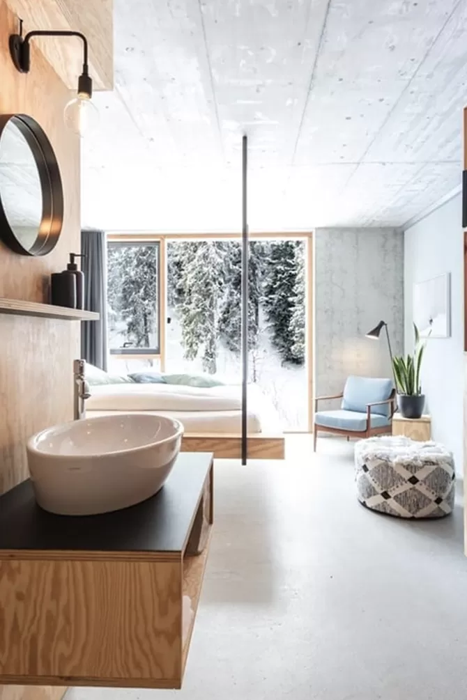 Interior luxury hotel suite with sink and view of snowy outdoors at Riders Hotel, Laax, Switzerland