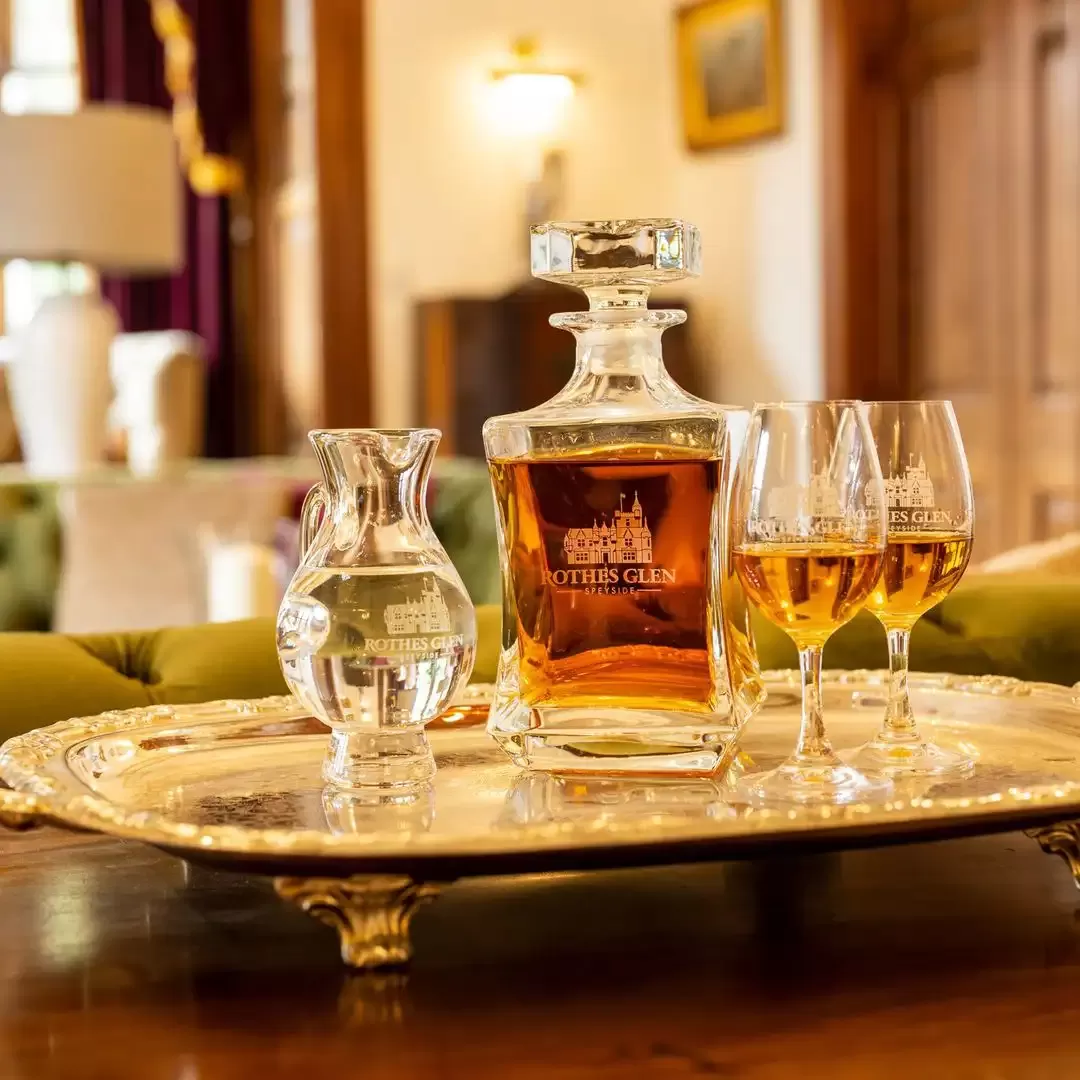 Sliver plate on legs on top displaying Scotch whiskey with serving glasses at Rothes Glen, Scotland