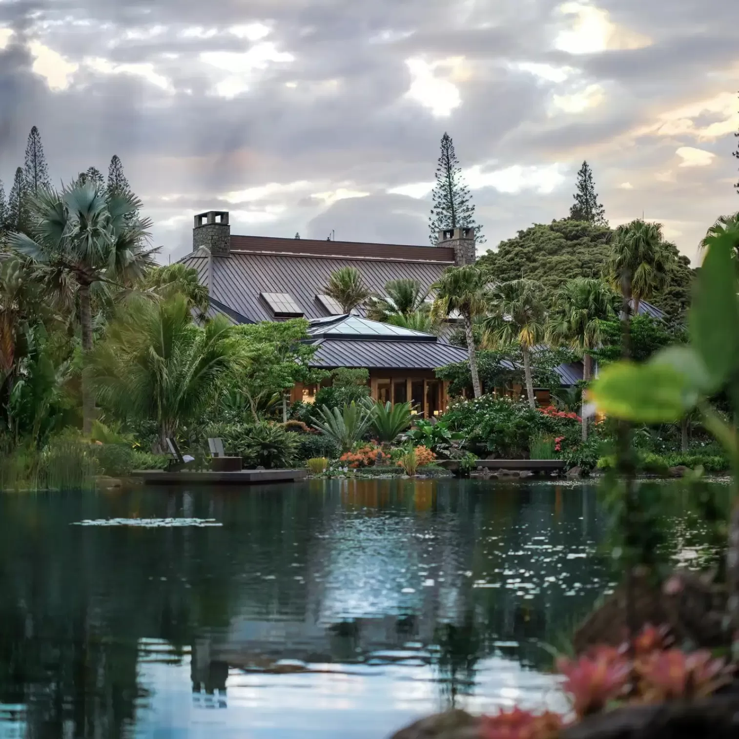 View of exterior of hotel through lake and trees at Sensei Lanai, A Four Seasons Resort, Hawaii