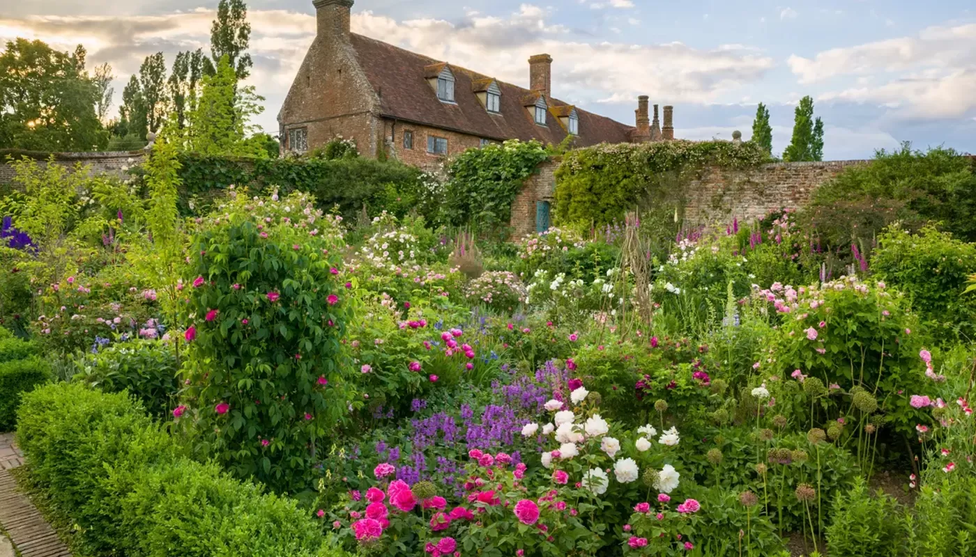 Countryside gardens filled with flowers outside an old brick house at Sissinghurst Castle Garden, Kent