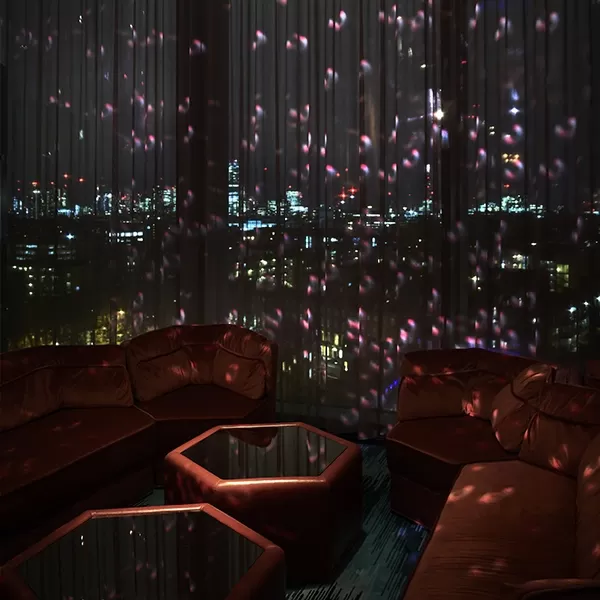Dark and red nighttime interior with a view of London at Sweeties Bar at The Standard London