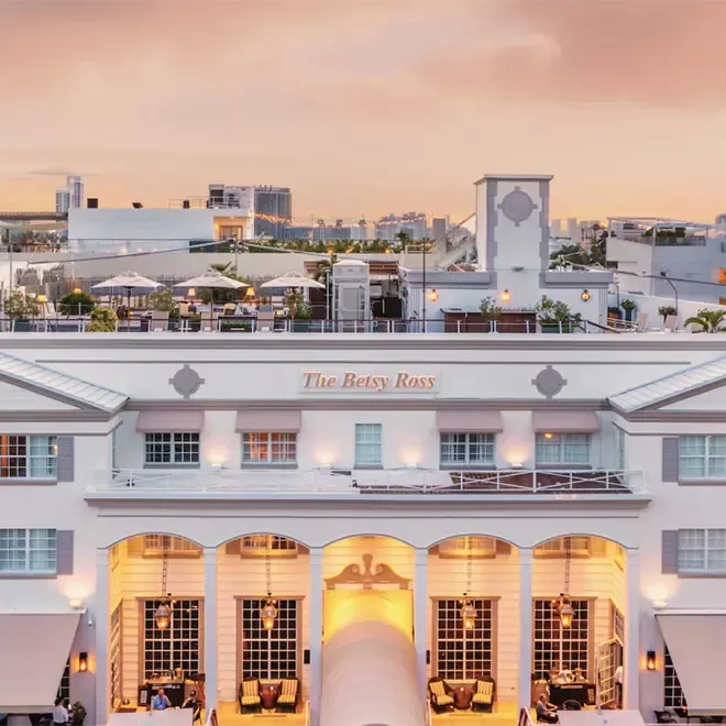 The front of the Betsy South Beach hotel. Tall white pillars with a rooftop area