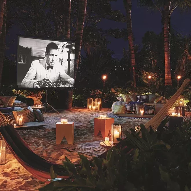 A beach with an outdoor cinema and comfy chairs and hammocks