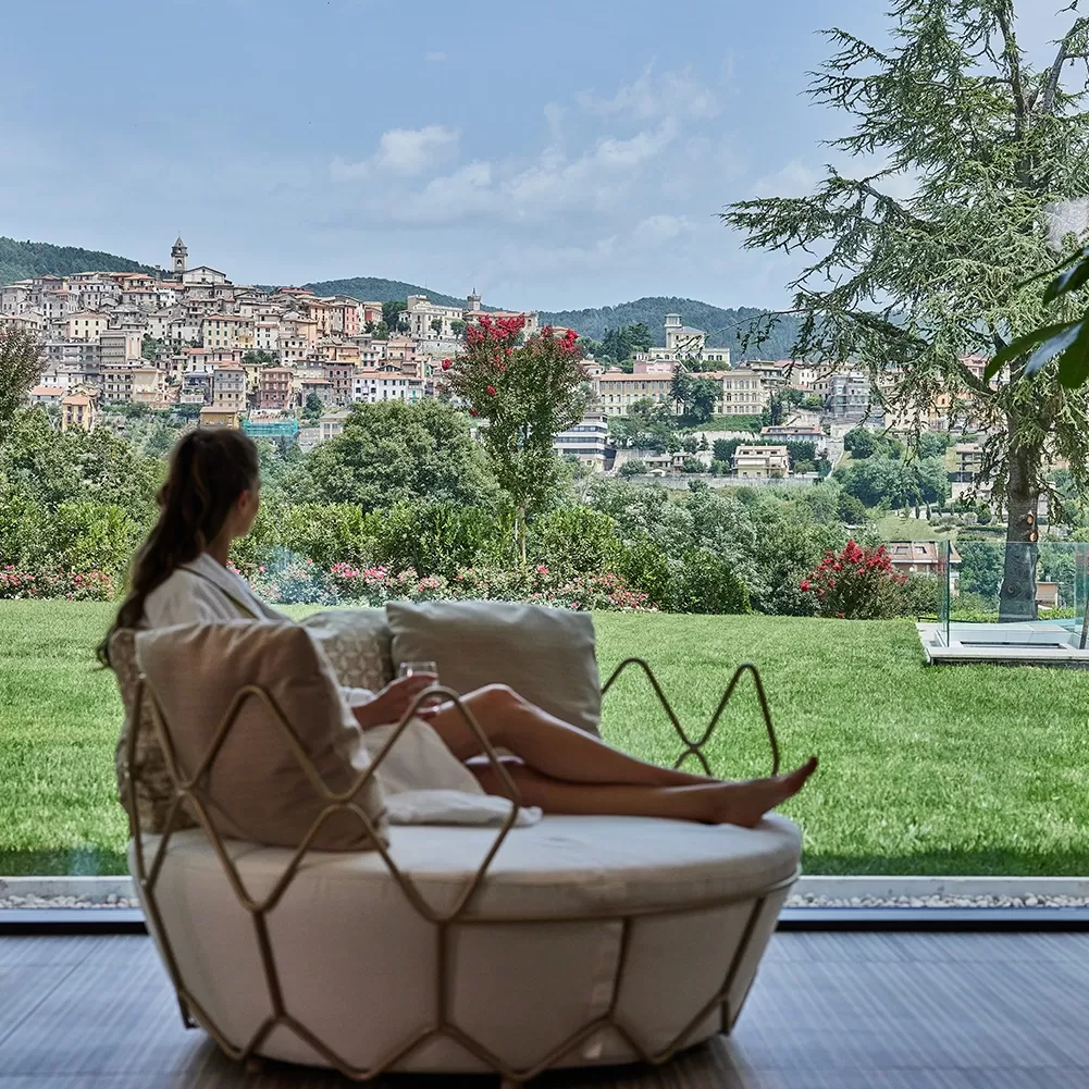 Women sat on chic round sofa with hexagonal outline casing overlooking landscape view at The Ranch, Malibu