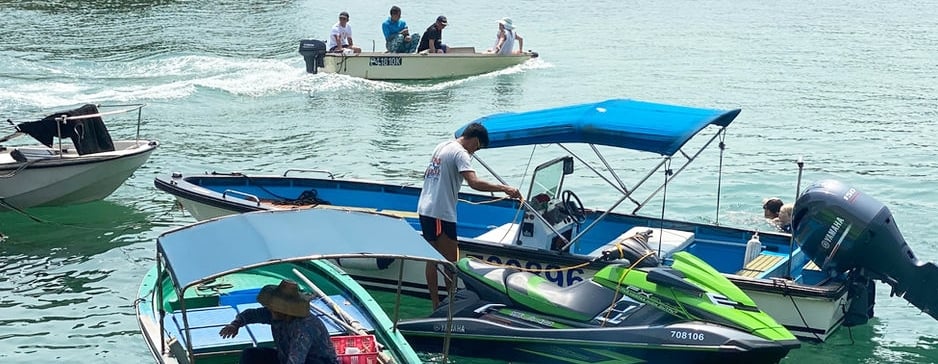 Small boats, dinghies and jet ski's powered by men on the lake