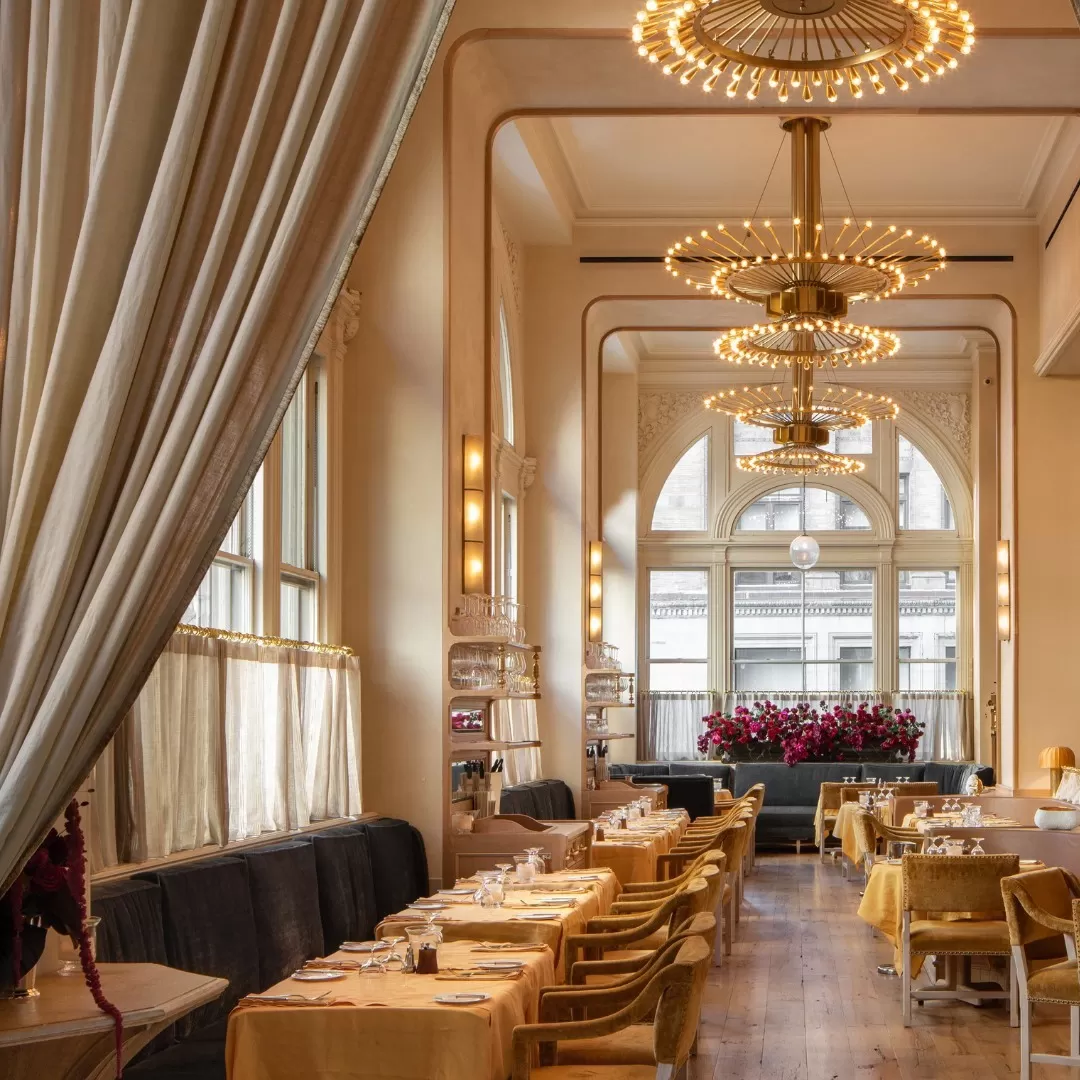 Rows of dining tables in grand luxury interior with hanging lights at Veronika, Gramercy Park, New York