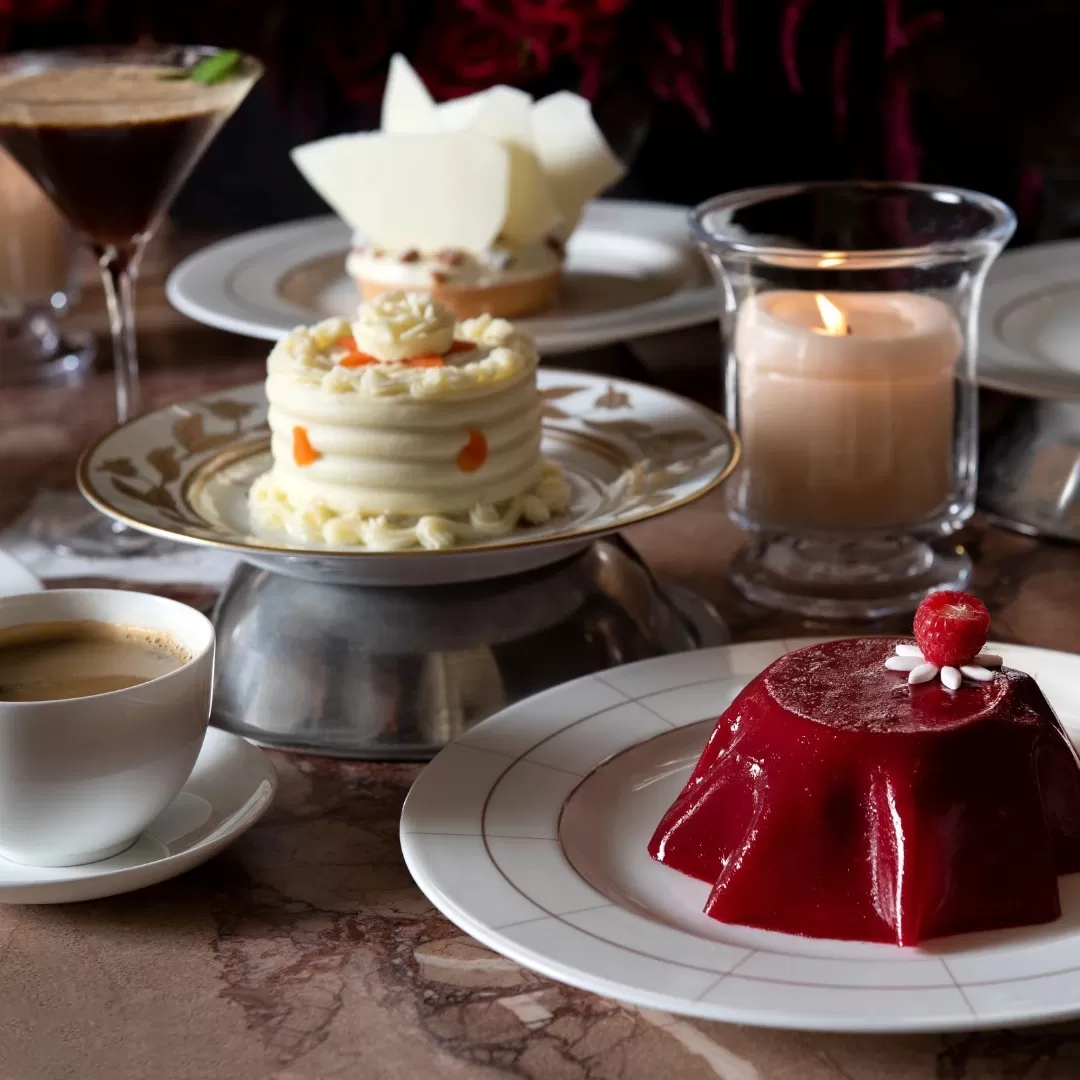 Variety of luxury desserts served on plated with a candle and coffee at Veronika, Gramercy Park, New York
