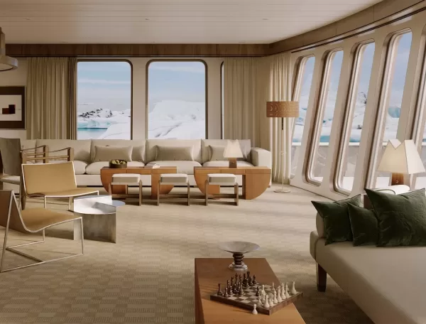 Luxurious living room with large windows showcasing an arctic landscape. The décor features neutral tones, modern furniture, a chess set on a wooden table, and two abstract paintings. Natural light fills the space.