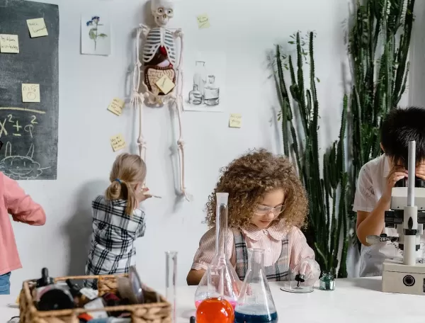 Children with science equipment in a classroom experimenting