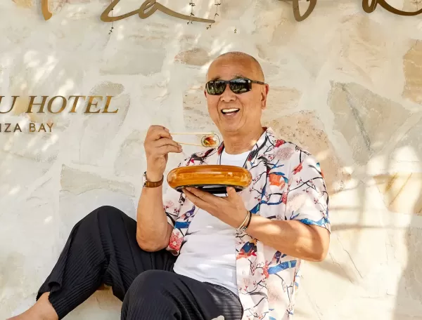 World-renowned chef Nobu Matsuhisa eating food sat outside of Nobu hotel Ibiza Bay, Ibiza