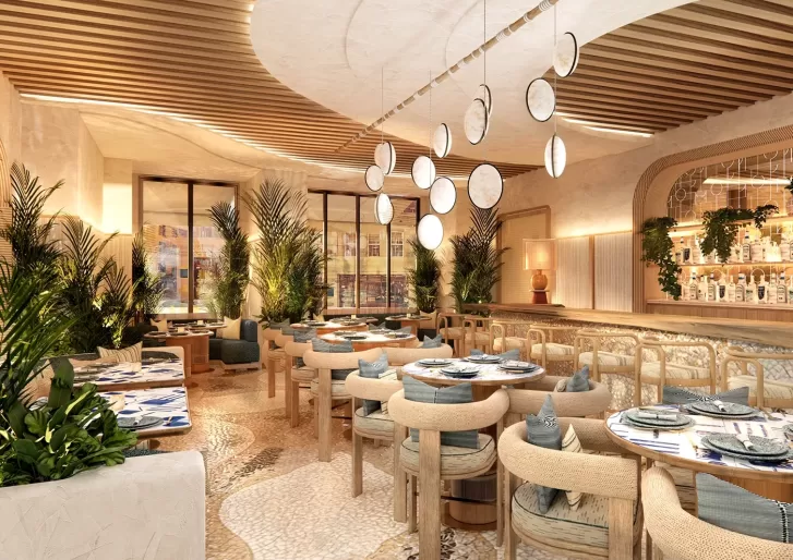 A modern restaurant interior with neutral tones, wooden furniture, round tables, green plants, and decorative hanging lights; sunlight streams through large windows, creating a warm, inviting atmosphere.