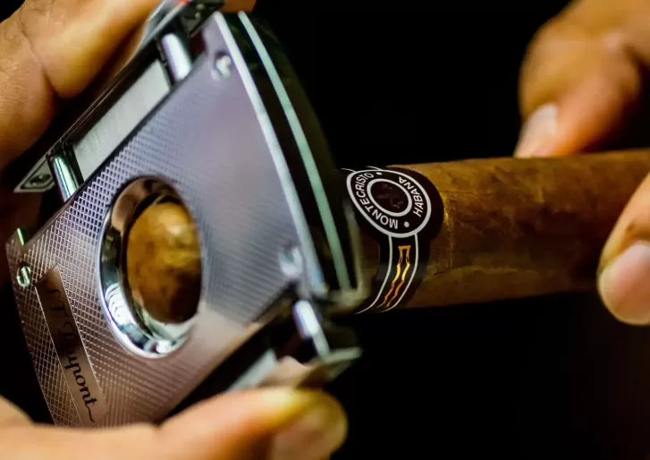 Person cutting a Cigar with tool a Marty's Chez Tabac shop, Toronto, Canada