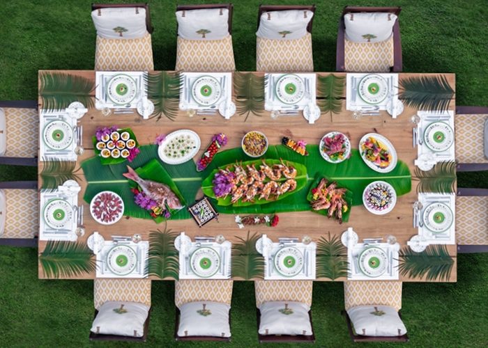 Above shot looking down on beautifully set dining table filled with food outdoors