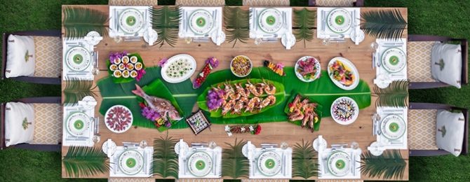 Above shot looking down on beautifully set dining table filled with food outdoors
