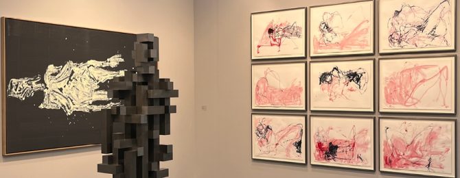Photos hanging on the wall next to a sculpture at Frieze