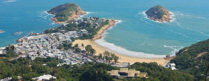 Birds eye view of small town and costal beach and blue sea at The Dragons Back coast
