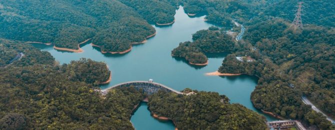 Birds eye view of grand lake of Wilson trial surrounded by green bushes and trees towards Kong Kong city