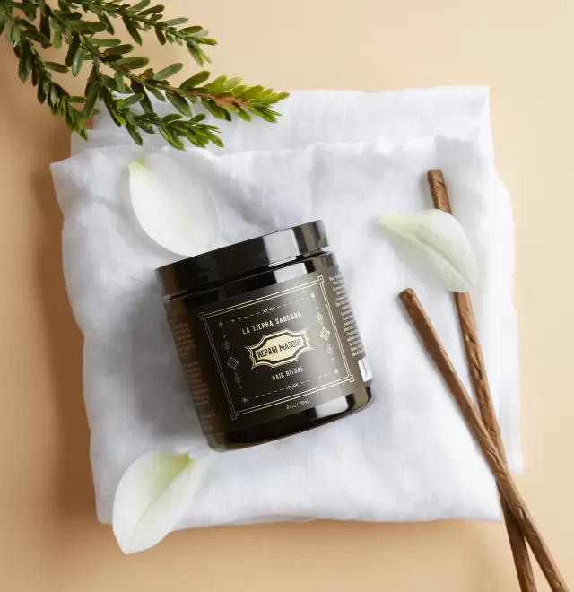Bottle of La Tierra Sagrada Repair Masque displayed with flannel and vanilla sticks