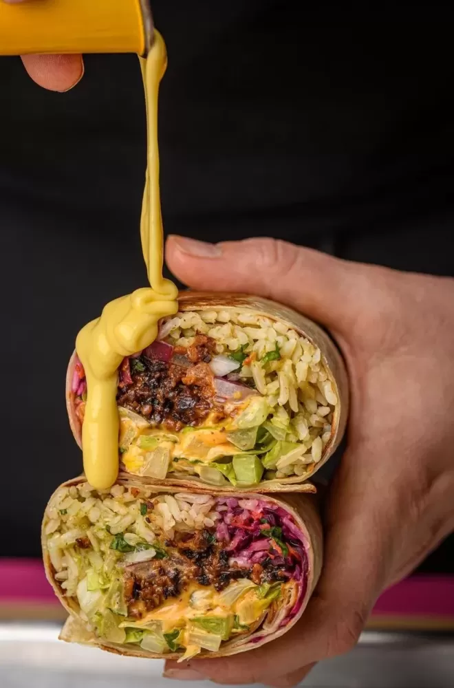 Burrito with sauce held by a person at Club Mexicana, Carnaby Street