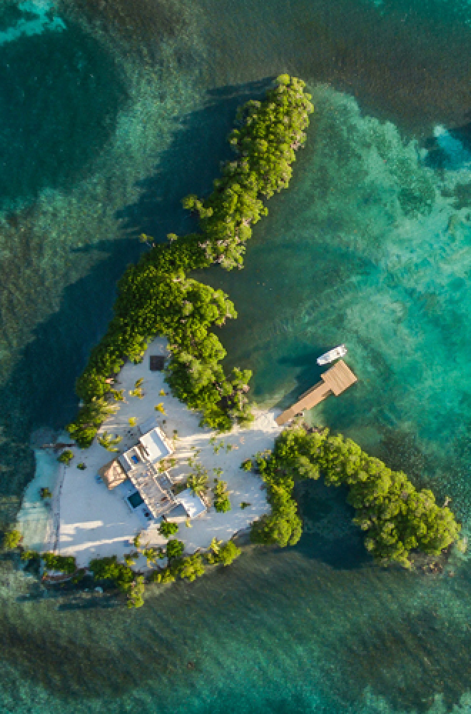 Birds eye view of Gladden Island, Belize. Beautiful trees surrounded by green and blue sea