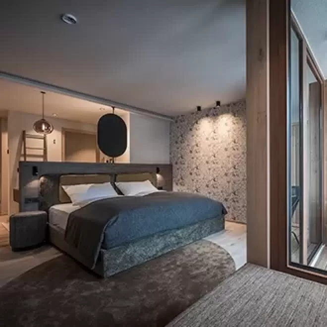 Inside luxury hotel suite, with velvet double bed at Hotel Badia Hill, Dolomites