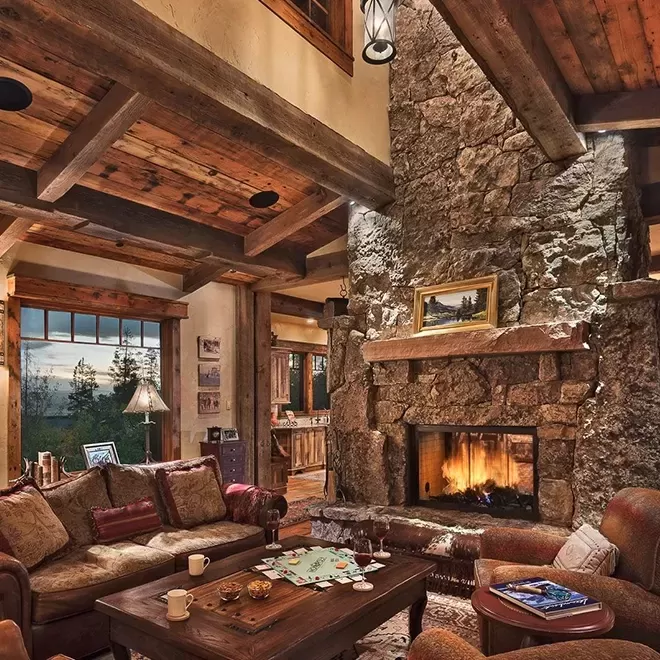 Luxurious cosy ski lodge interior with stone walls, wooden interior and wood burning fire