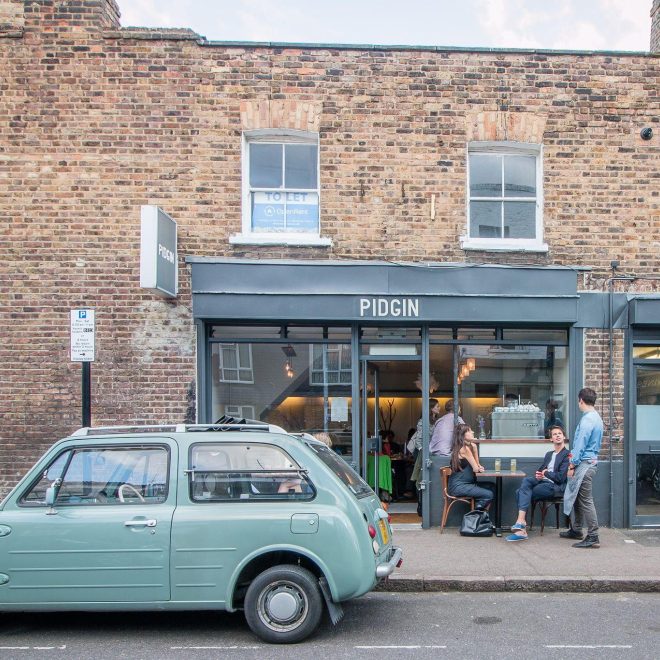 Exterior building and green vintage car outside Pidgin from the street