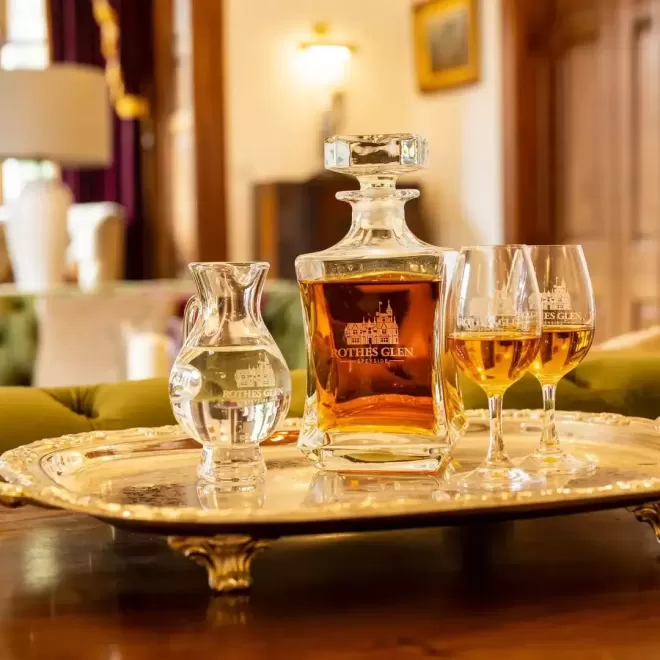 Sliver plate on legs on top displaying Scotch whiskey with serving glasses at Rothes Glen, Scotland