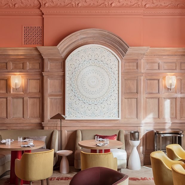 Contempory dining area in front of a painting on wooden paneled wall