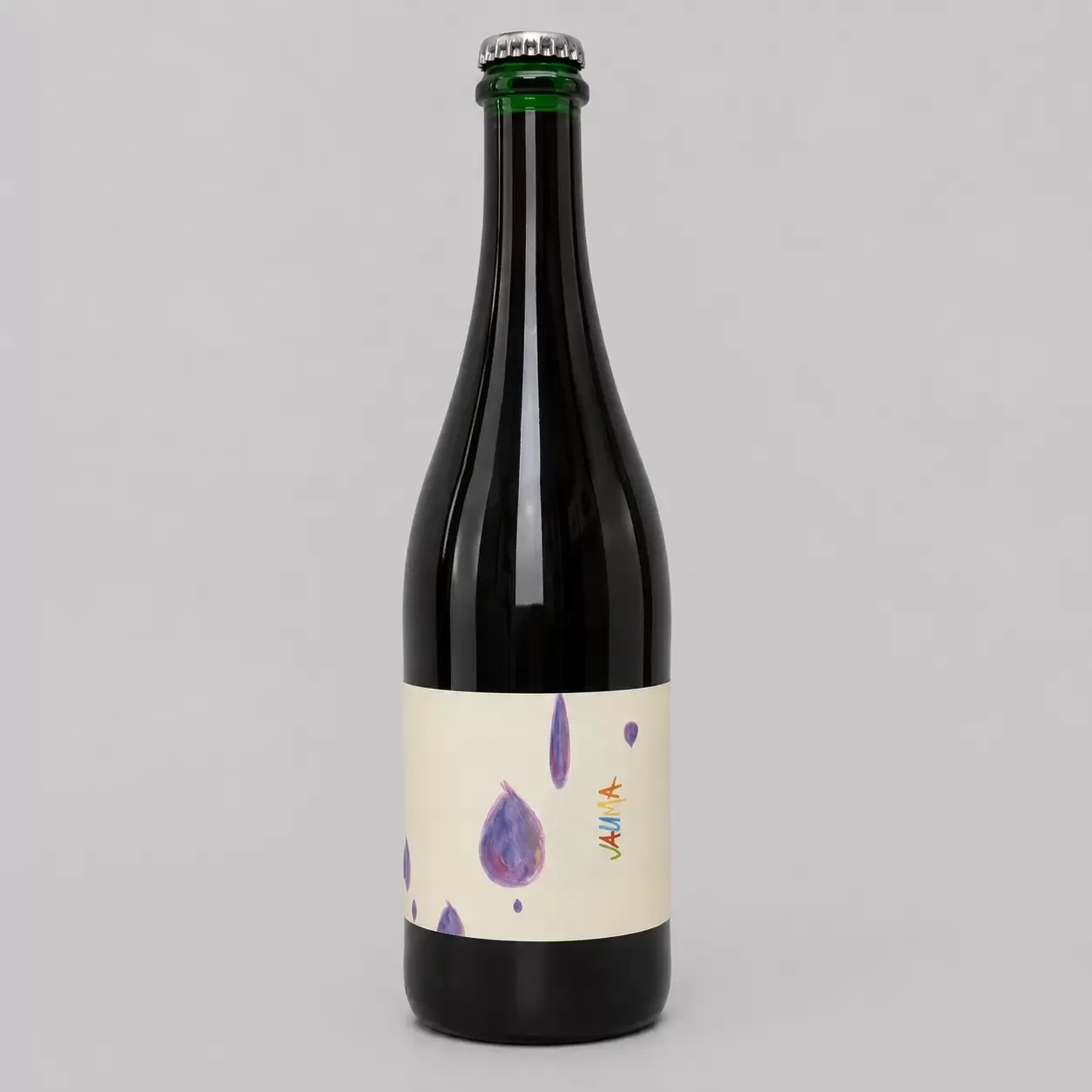 A dark glass bottle with a silver cap and a white label featuring purple watercolor droplets and small colorful lines, set against a plain light gray background.