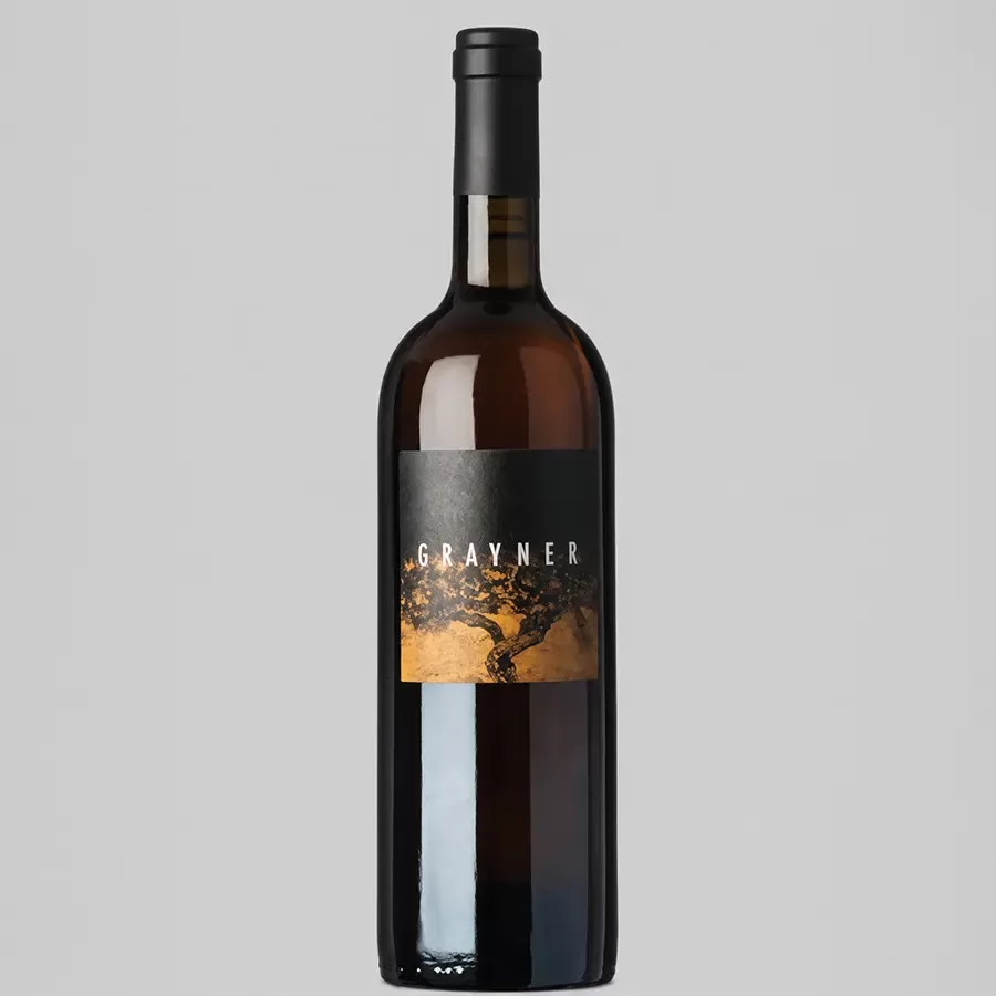 A dark glass wine bottle with a black and gold label reading GRAYNER stands upright against a plain light gray background.