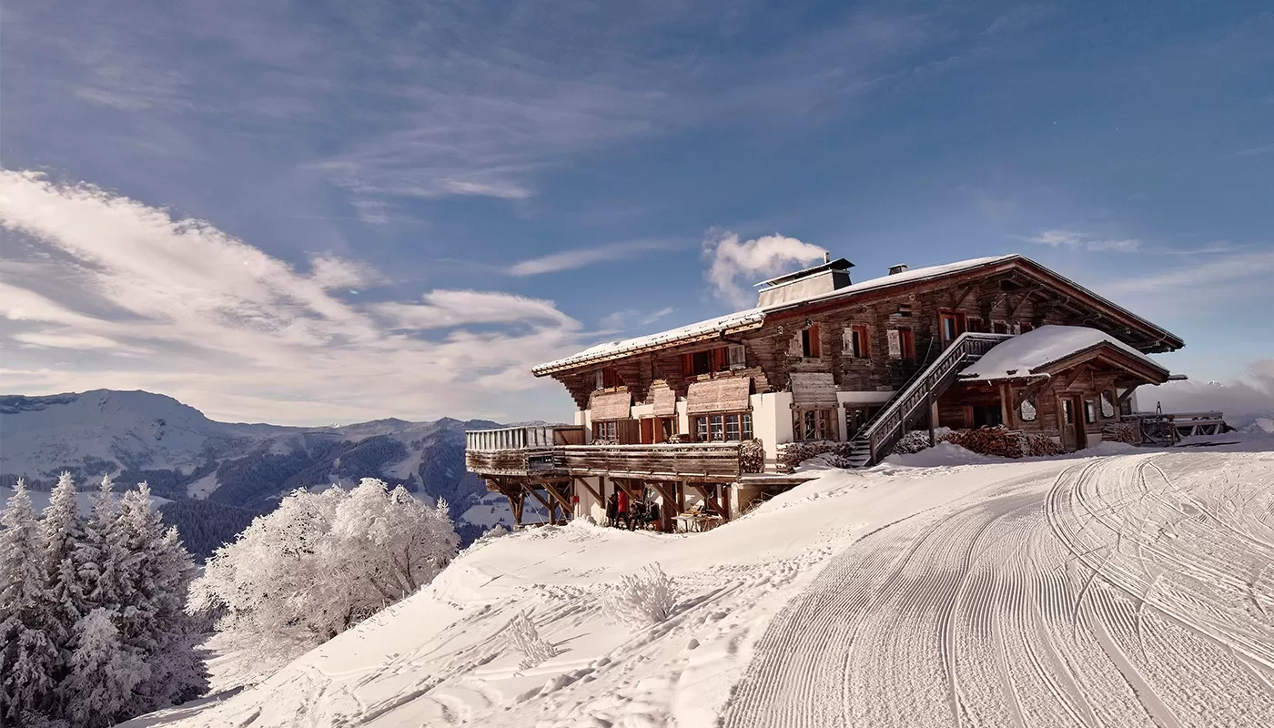 Exclusive ski lodge hotel on the top of a snowy mountain with a view of mountains at The Four Seasons Megeve Collection, France