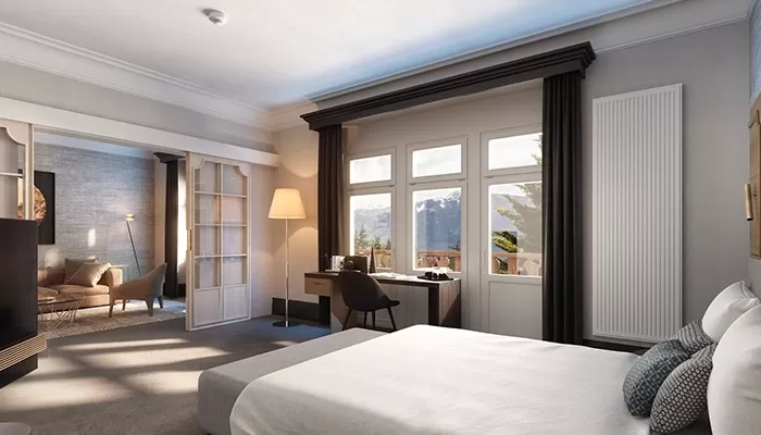 Inside luxury hotel suite with view of snowy mountains at Villars Palace, Switzerland