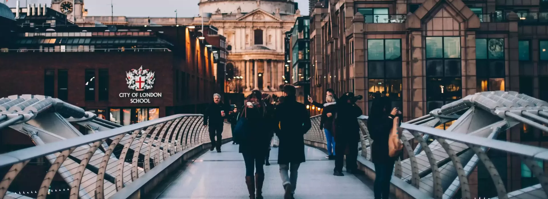 People walking across bridge in London towards St. Pauls Cathedral