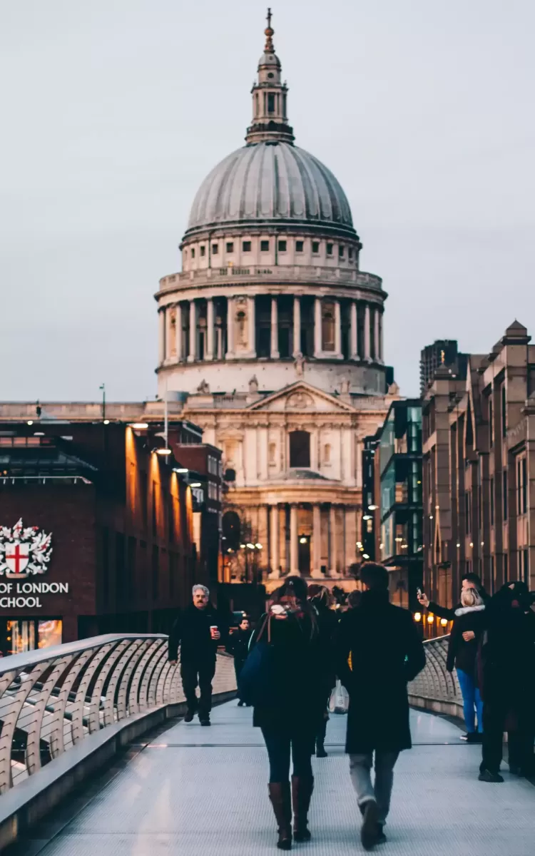 People walking across bridge in London towards St. Pauls Cathedral